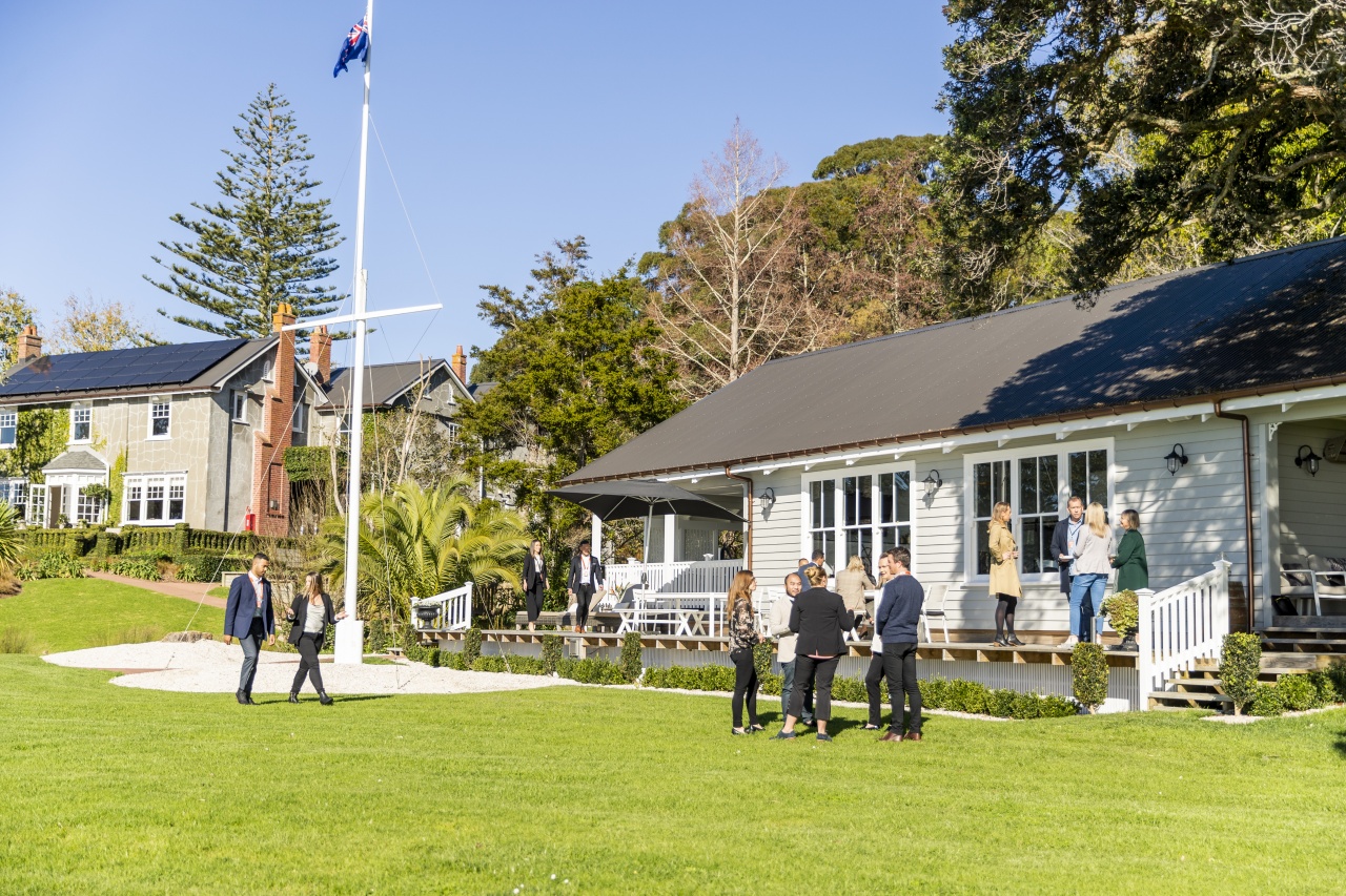 Delegates interact in front of boathouse