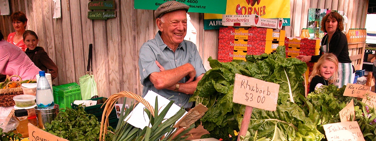 A happy vendor behind his fresh produce at Clevedon Markets