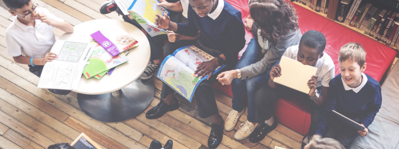 overhead shot of children sitting around learning