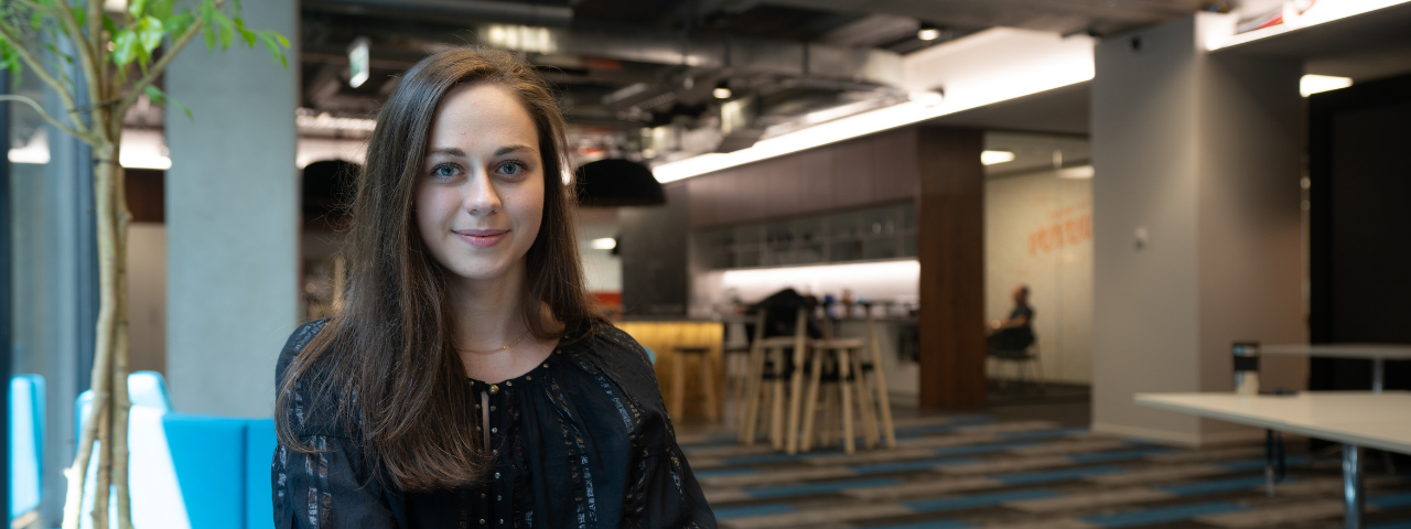 Photo of Tetiana Perevernykhata sitting on a couch looking at a camera