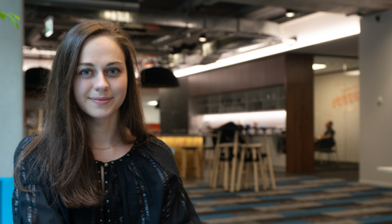 Photo of Tetiana Perevernykhata sitting on a couch looking at a camera