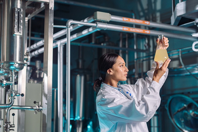 Female food and beverage food technologist looking at a sample of liquid
