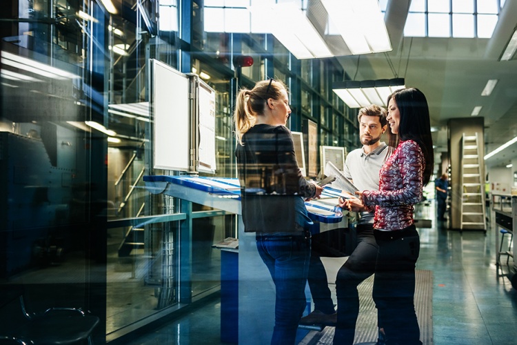 Team of three standing around a table working